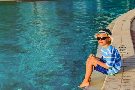 happy cute little boy sitting at the pool, vacation conceptの写真素材