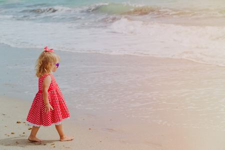 little girl walk on sand beach, family vacation conceptの写真素材