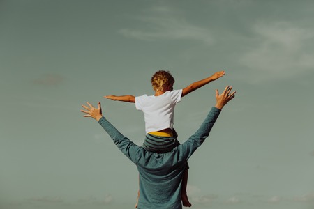 father and son having fun on sky, family and parentingの写真素材