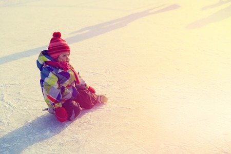 cute little girl learning to skate in winter natureの写真素材