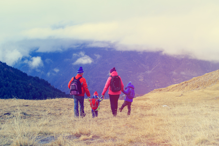 family with two kids hiking in winter mountains, family travelの写真素材
