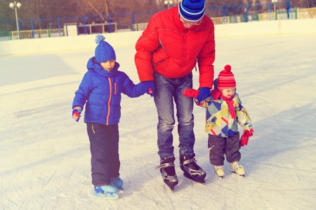 father with two kids skating in winter, family sportの写真素材