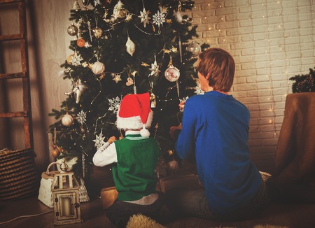 father and little son decorating Christmas treeの写真素材
