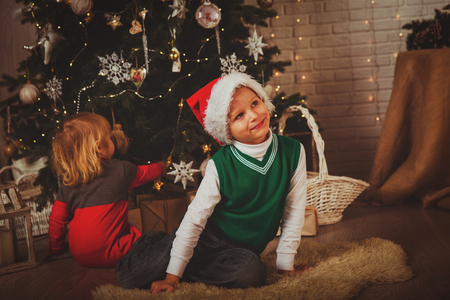 Christmas in family -little boy and girl decorating Christmas treeの写真素材