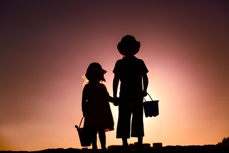 little boy and girl with beach toys at sunset, family beach vacationの写真素材