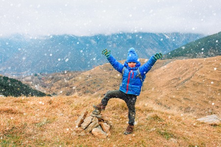 happy little boy enjoy hiking in winter snow mountainsの写真素材