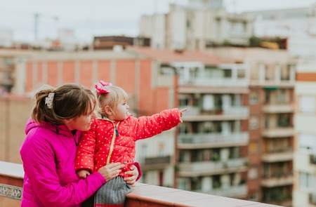 mother and little daughter looking at the city, family travelの写真素材