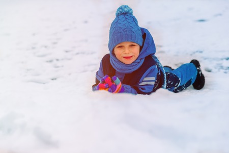 happy little boy having fun in winter snow natureの写真素材