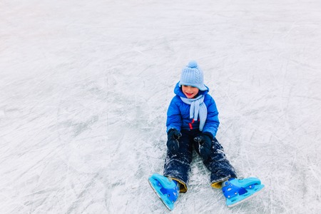 cute little boy learning to skate in winter snowの写真素材