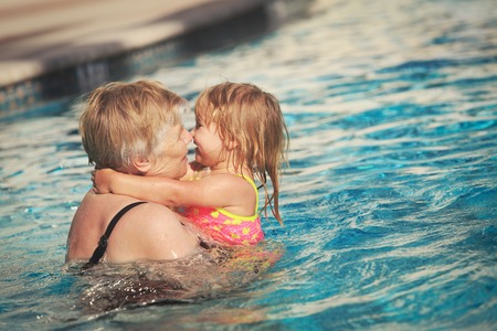 Grandmother and granddaughter swimming at pool, active retirementの写真素材