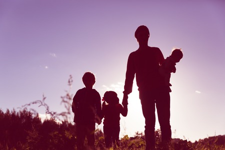 father with tree kids walk in sunset nature, happy familyの写真素材