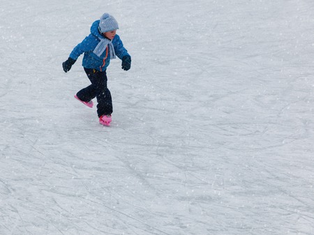 little boy skating on ice in winter natureの写真素材