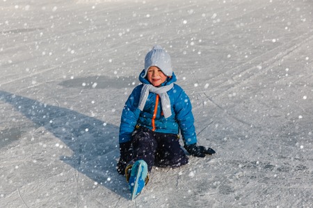 cute little boy learning to skate in winter natureの写真素材