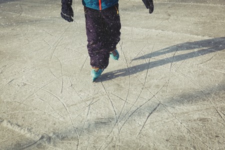 little boy skating on ice in winter natureの写真素材