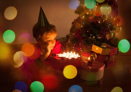 cute little boy blowing candles at Christmas, Christmas celebrationの写真素材