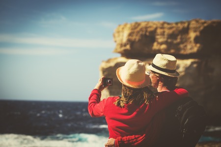Tourist couple making selfie photo on Azure Window in Gozo island, Malta