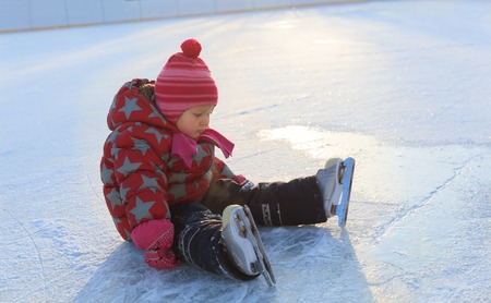 cute little girl learning to skate in winter natureの写真素材