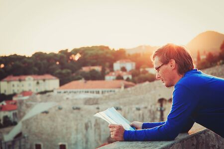 travel concept -tourist looking at map in the city of Dubrovnik at sunsetの写真素材