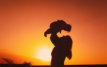 mother and little baby play at sunsetの写真素材