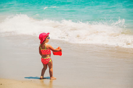 little girl play with water at beachの写真素材
