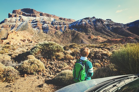 little boy travel by car in scenic mountainsの写真素材