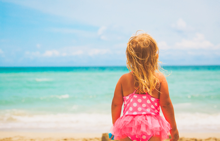 little girl looking at beach, tropical vacation conceptの写真素材