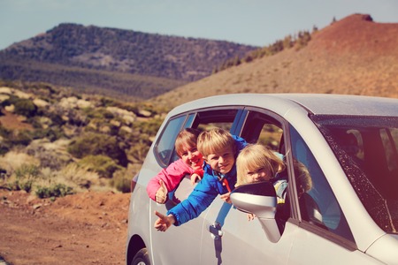 happy mother with two kids travel by car in natureの写真素材