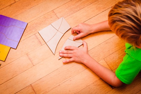 learning math - little boy playing with puzzleの写真素材