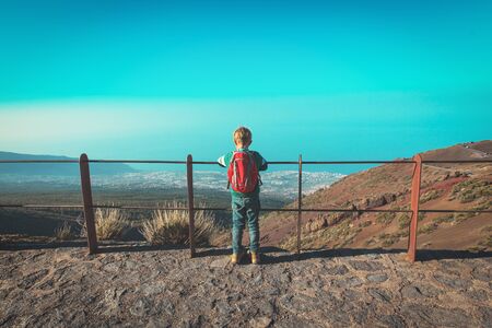 little boy looking at beautiful view while travel in mountains