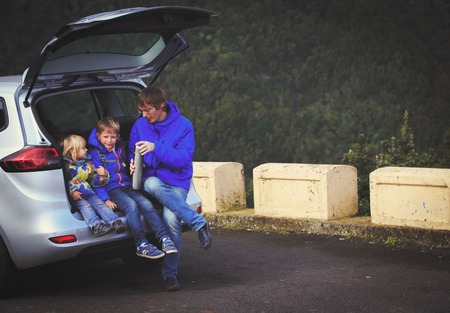 family travel by car- happy father with kids on roadの写真素材