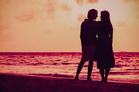romantic couple holding hands at sunset beachの写真素材