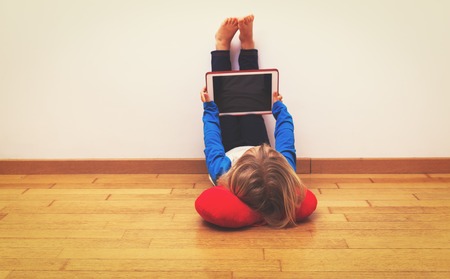 little girl looking at touch pad, home learningの写真素材