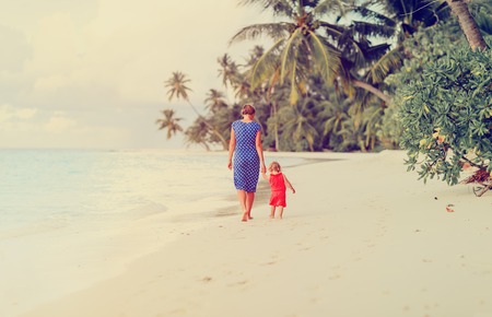 mother and little daughter walking on beachの写真素材