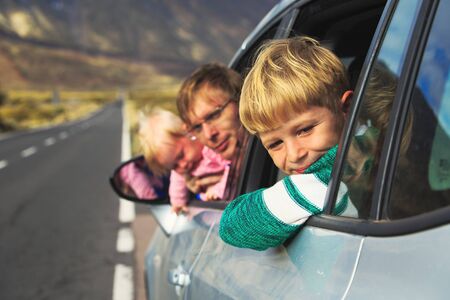 family travel by car- happy father with kids in mountainsの写真素材