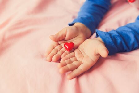 love and family concept. little girl holding heart in handsの写真素材