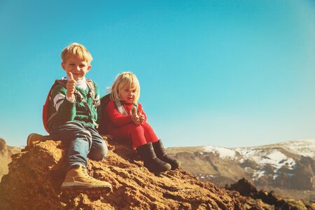happy little boy and girl enjoy hiking in mountainsの写真素材