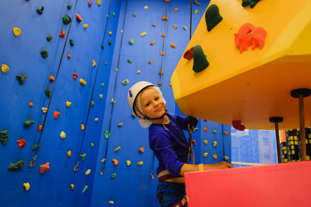 little boy climbing wall in sport centerの写真素材