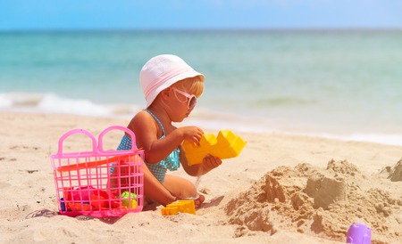 cute little girl play with sand on beachの写真素材