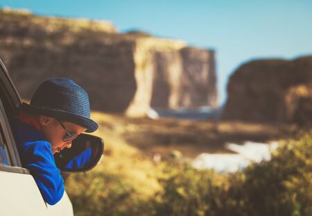 happy little boy travel by car in natureの写真素材