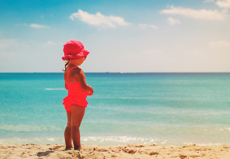 little girl looking at beach, tropical vacation conceptの写真素材