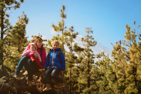 mother with two kids hiking in mountainsの写真素材