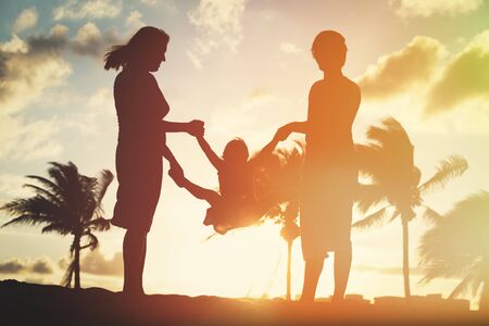 happy family with child play on sunset beachの写真素材