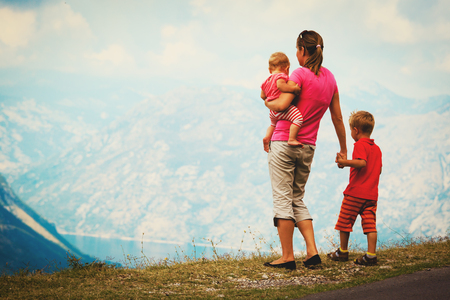 mother with two kids travel hiking in mountainsの写真素材