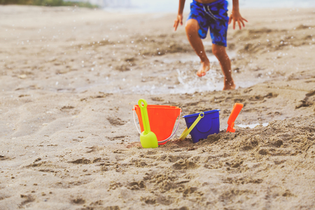 kids toys and little boy playing on beachの写真素材