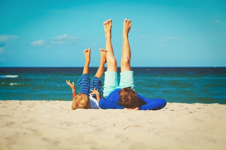 father and little son play on beachの写真素材