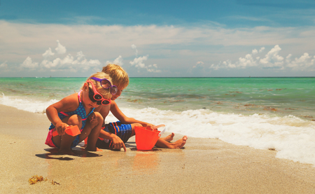 kids play with sand on summer beachの写真素材