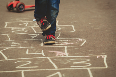 little boy playing hopscotch on playgroundの写真素材