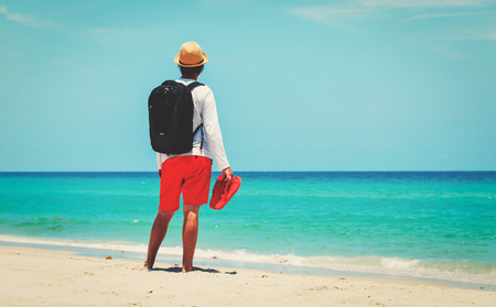 remote work -man with backpack and laptop on beachの写真素材