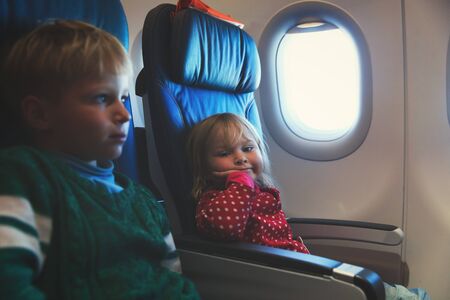 little girl and boy travel by plane