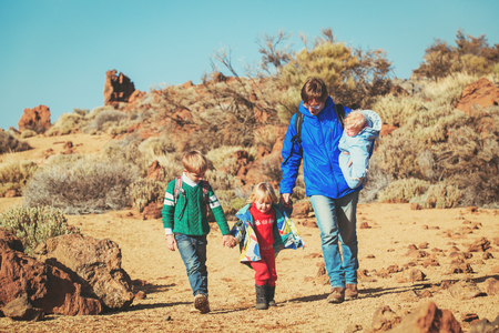 father with three kids travel hiking in mountainsの写真素材